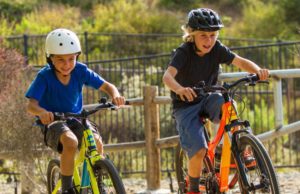 Two kids playing bikes with helmets